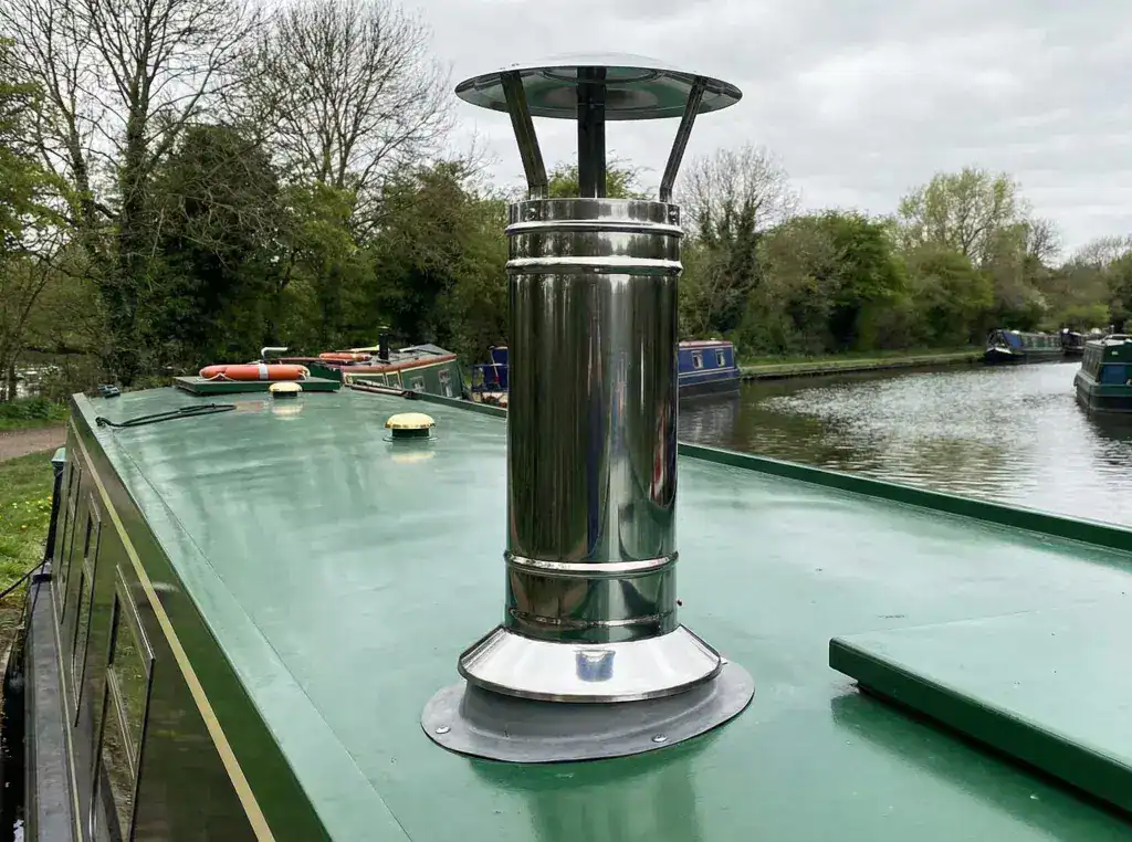 A professionally installed stainless steel twin-wall insulated flue terminal on a boat roof