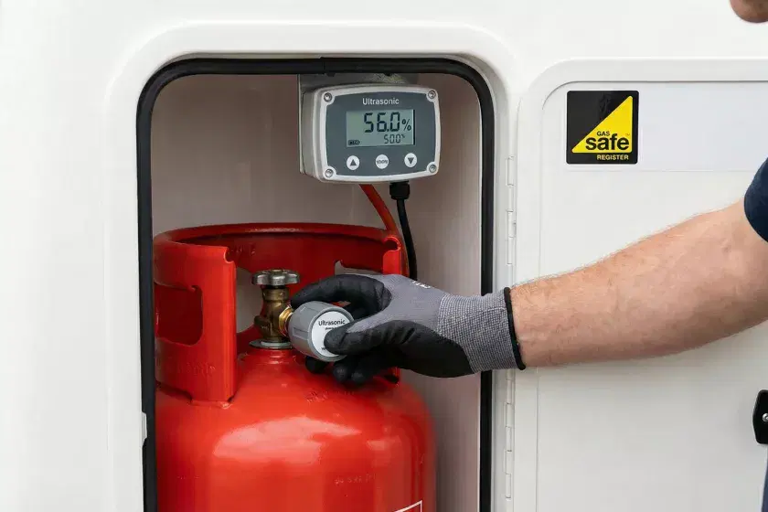A professional technical shot showing an ultrasonic gas bottle gauge being fitted to a marine cylinder for precise LPG monitoring.
