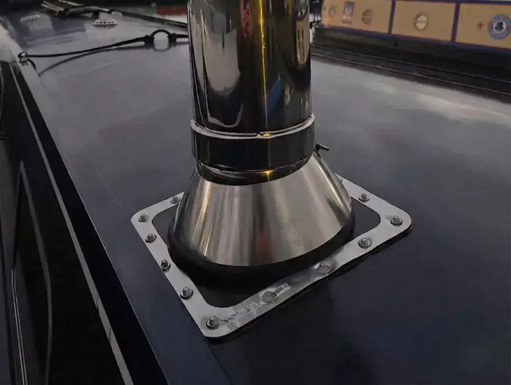 A BS 8511 compliant double-walled insulated marine flue installation on a narrowboat roof with a waterproof deck seal and storm collar.