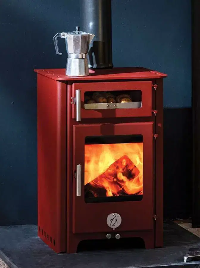 Fat Penguin 5kW multifuel stove featuring side convector panels and an integrated oven with a baking tray inside.