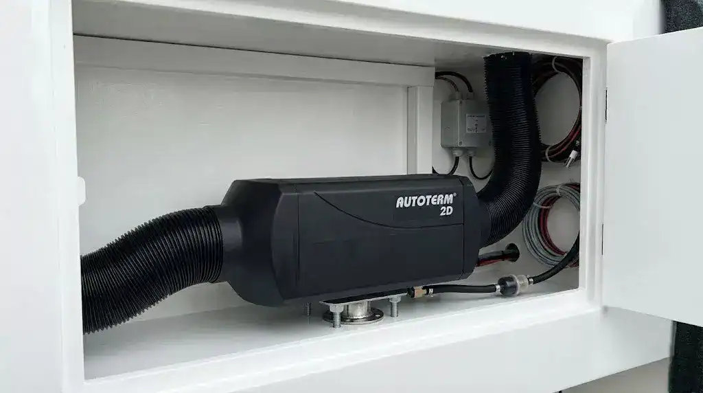 Professional installation of an Autoterm 2D diesel heater inside a white marine compartment with neat wiring and ducting.