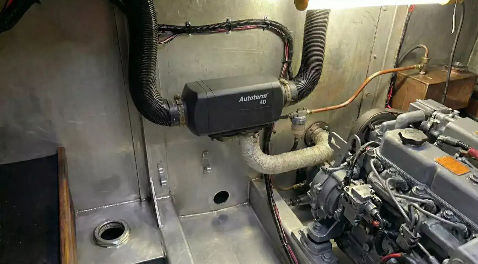 Professional installation of a high-capacity Autoterm 4D diesel heater in a narrowboat engine bay with top-routed air ducting and clear fuel filter.