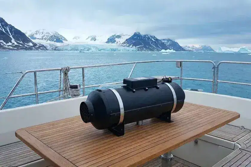 An Autoterm 9D 8kW diesel heater positioned on the rear deck of a large yacht sailing through icebergs in the Arctic Circle.