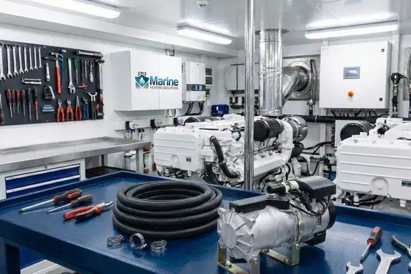 An Autoterm Flow 14TC-Mini diesel water heater on a professional engine room workbench with a Marine Heating Solutions logo in the background.