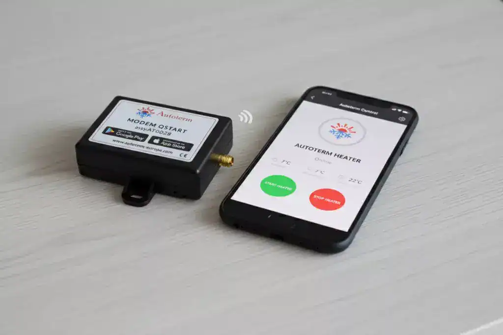 Autoterm QSTART modem alongside a smartphone displaying the Autoterm Control app interface for remote heater operation.