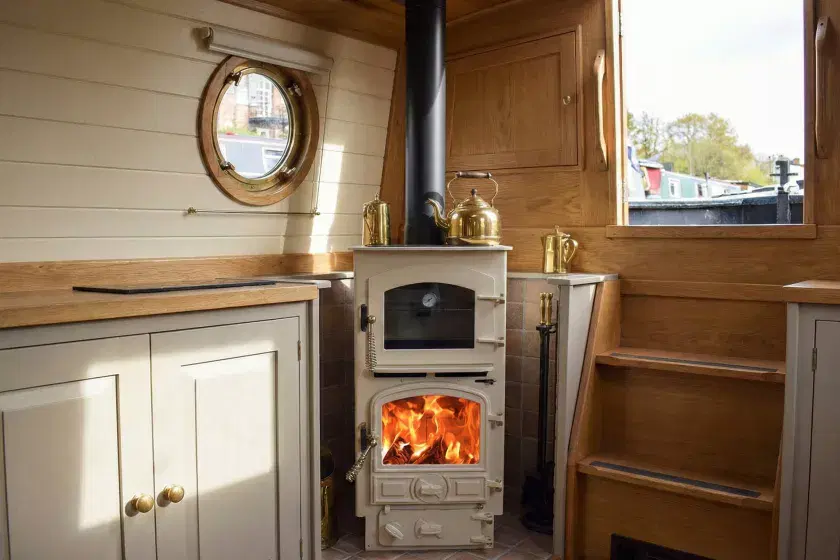 Cream Bubble 4B Pie Pod 2 multi-fuel stove installed in a narrowboat cabin with a black twin-wall insulated flue and brass accessories.