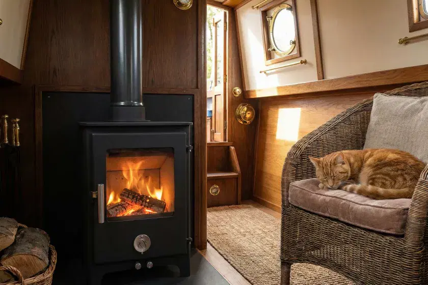 Chilli Penguin Short Penguin multi-fuel stove installed on a narrowboat by Marine Heating Solutions, featuring a cozy interior with a sleeping cat.