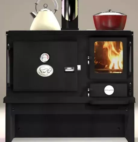 The Salamander Little Range solid fuel boat cooker with a burning fire, featuring a large hotplate with a kettle and a built-in oven with a temperature gauge.