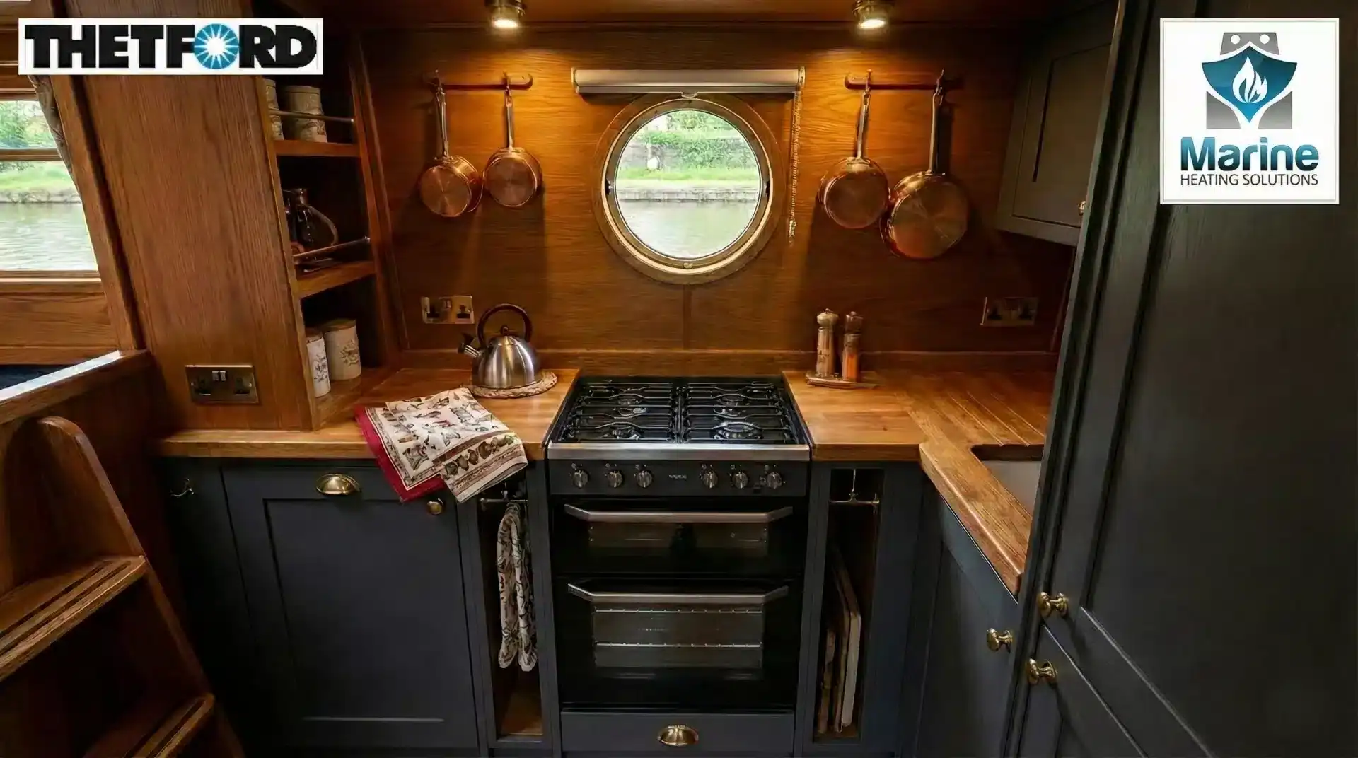 Thetford Cocina black glass LPG cooker installed in a modern narrowboat galley with wood interiors and a porthole window.