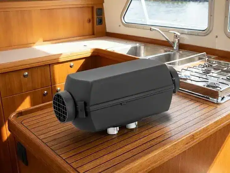 Autoterm Air 2D 2kW compact diesel heater unit in a matte black finish, shown uninstalled on a boat's wooden interior surface to highlight its small footprint.