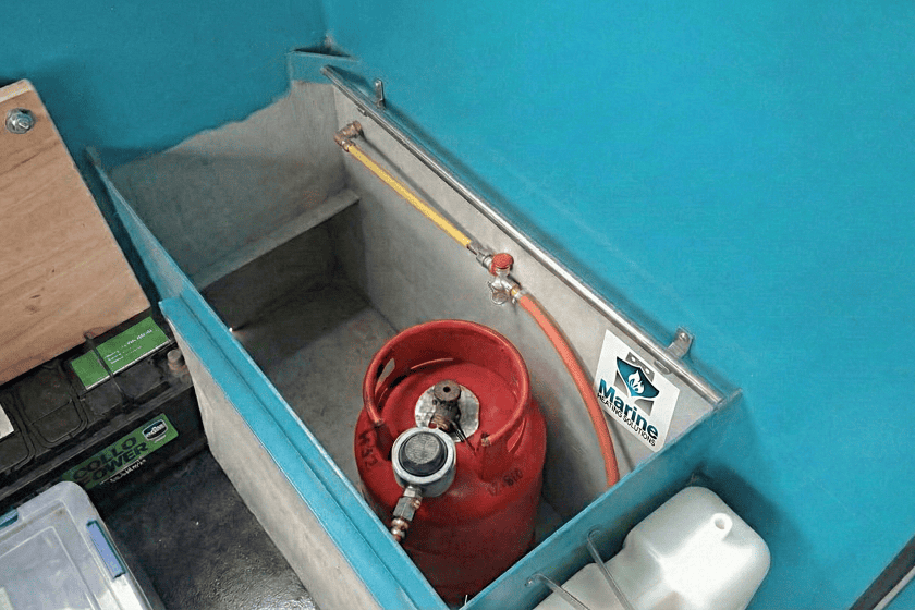 A professional marine gas locker installation on a narrowboat, showing a Gas Safe compliant LPG cylinder setup with secure copper pipework and Marine Heating Solutions branding.