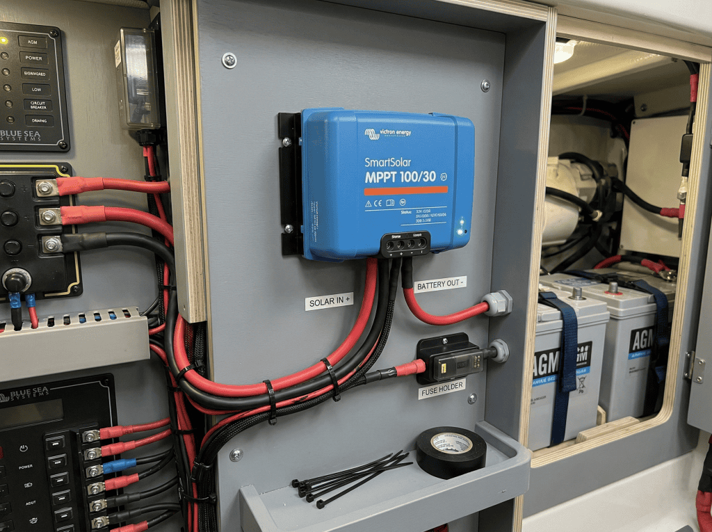 Close-up of a professionally installed marine-grade MPPT solar charge controller with heat-shrink terminals and BSS-compliant fusing.